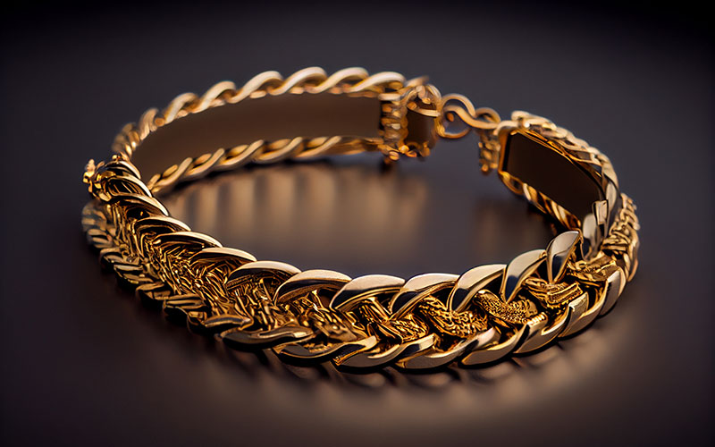 Ein goldenes Armband liegt auf einem dunkelgrauen Tisch.